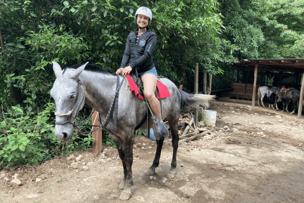 girl riding horse at el tigre waterfall in monteverde. 